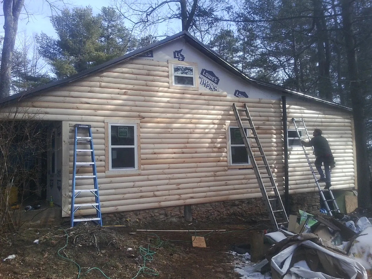Ladders set against fresh log siding during an exterior remodel in Lapwai