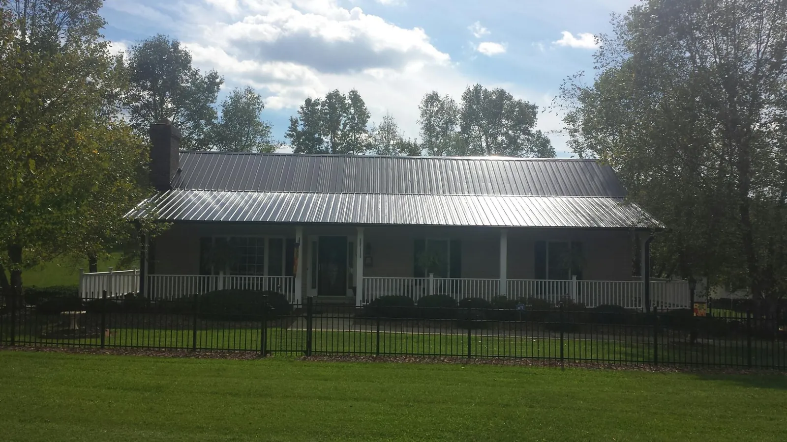 Gray metal roof on a brick ranch with a full width front porch — Gutter Guard Installation work by our crew in Lapwai